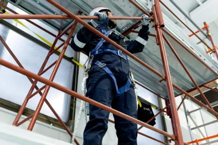 Operatore con imbracatura anticaduta su un ponteggio durante l’addestramento al lavoro in quota